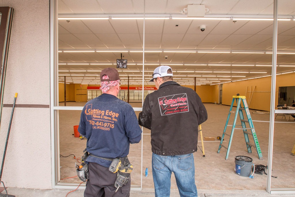A Cutting Edge Glass and Mirror Employees Working On Family Dollar Storefront
