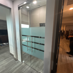 ½” heavy glass doors; brushed stainless hardware; custom satin etch design